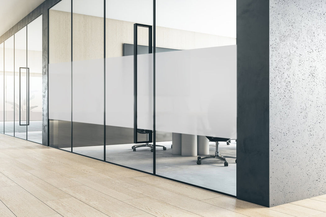 Perspective view on stylish meeting room behind glass door with modern conference table surrounded by black chairs, TV on light wall and dark grey concrete walls. 3D rendering