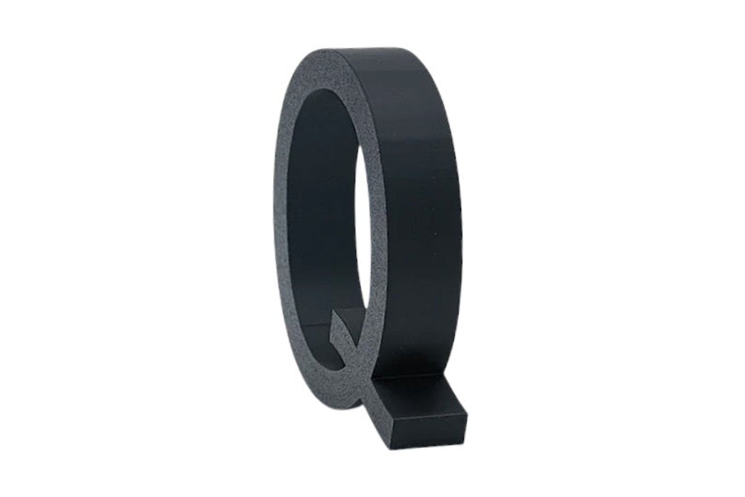 Letra corpórea inclinada impresa en 3D color negro PLA con fondo blanco