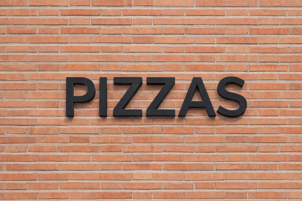 Rótulo exterior de la palabra "PIZZAS" impreso en PETG Negro en fachada