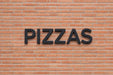 Rótulo exterior de la palabra "PIZZAS" impreso en PETG Negro en fachada